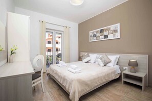 A hotel room with a bed, bedside table, lamp, and a view of the outside. - Holiday apartment with air conditioning and outdoor pool (Fažana)