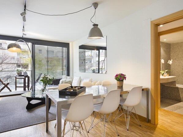 Enjoy meals in this stylish dining area with a long table and six chairs, illuminated by pendant lights.