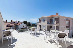 A rooftop terrace with outdoor seating and a view of the surrounding neighborhood. - Holiday apartment with air conditioning and outdoor pool (Fažana)