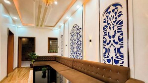 Un interior moderno con un sofá marrón, una mesa negra y paneles decorativos en la pared.