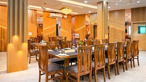 Un comedor amplio con paneles de madera, varias mesas y sillas.