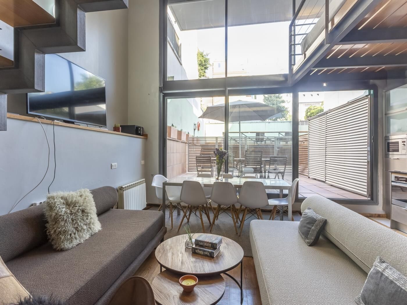 Un salon moderne comprenant un canapé, une table basse et un coin repas avec des chaises et une table.