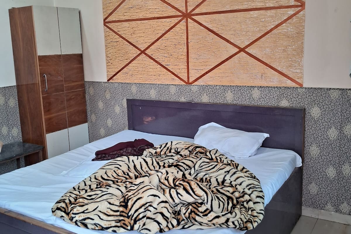 A bedroom with a bed, a wardrobe, and a geometric wall decoration.