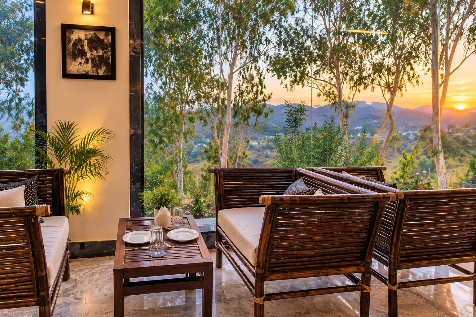 A seating area with a table set for two, overlooking a scenic landscape with trees and a sunset.