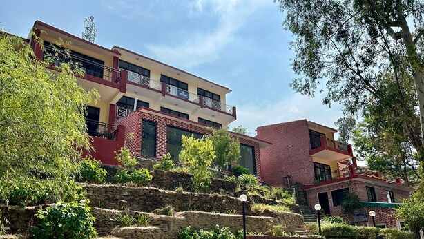 A multi-story building with a stone staircase leading up to a sign reading "Crestmont Snowview".