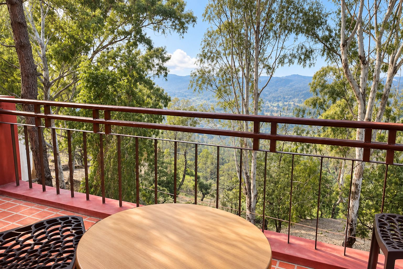 Een balkon met uitzicht op een bos en bergen.