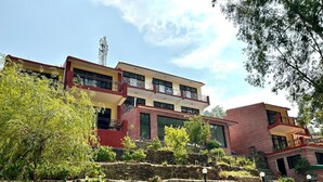 A multi-story building with a mix of brick and modern design elements, including balconies and large windows.