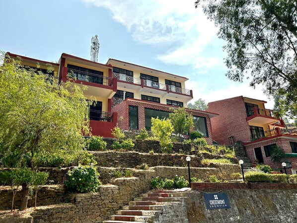 Un edificio de varios pisos con una combinación de ladrillo y elementos de diseño moderno, incluyendo balcones y ventanas amplias.