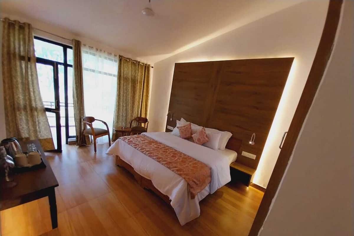 Un dormitorio moderno con una cama grande, cabecero de madera y un escritorio con una silla.