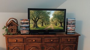 Ein Holz-Entertainment-Center mit Fernseher, DVD-Player und einer Reihe von DVDs.