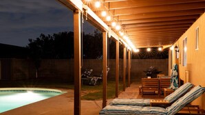 A covered outdoor area with a pool, lounge chairs, and a barbecue grill. - Arizona Daydream + Private Pool + EV Charger (Chandler)