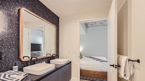 A modern bathroom with two sinks, a large mirror, and a towel rack. - 2BR + Luxury +Views +Rooftop pool in Austin (Austin)