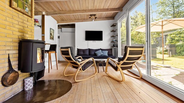 A cozy living room with a fireplace, a sofa, and rocking chairs. - 3 bedroom nice home in Melby (Melby)