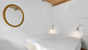 A bedroom with a bed, a round mirror, and two wall-mounted lights. - 3 bedroom nice home in Melby (Melby)
