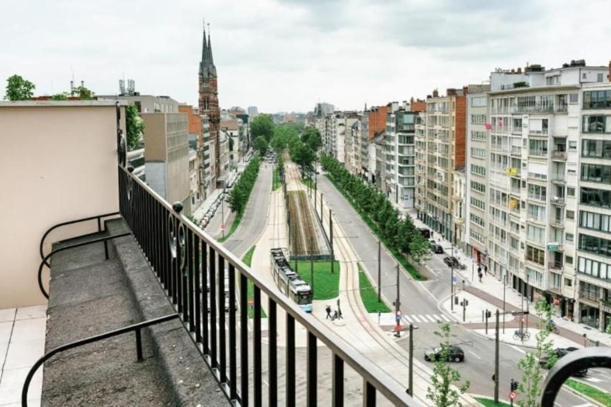 A cityscape with modern buildings, a tram, and a pedestrian crossing.