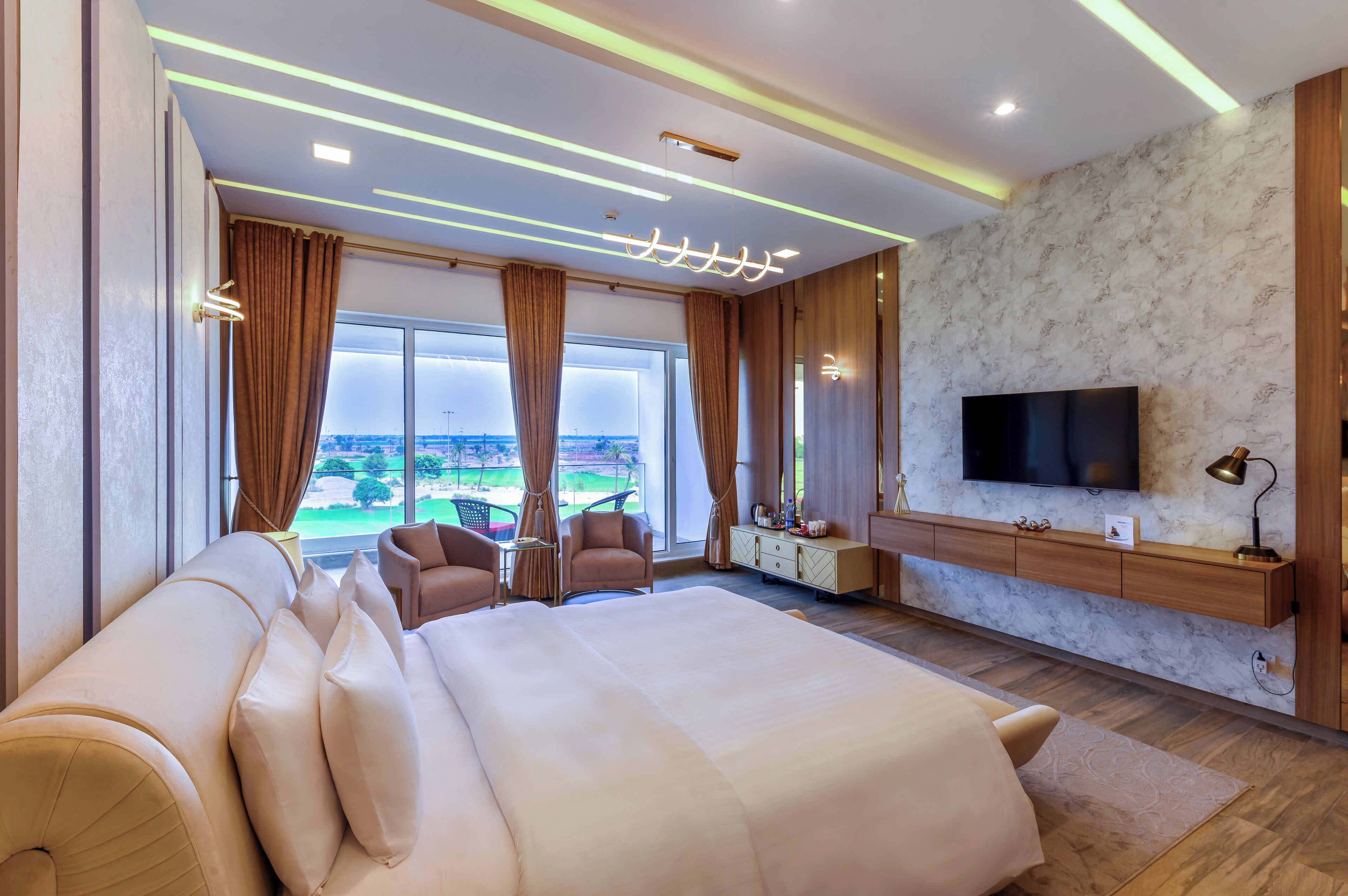 Una habitación de hotel moderna con una cama grande, televisión y vistas al exterior.