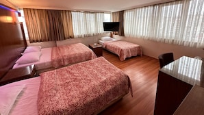 A hotel room with two beds, a TV, a desk, and large windows with curtains. - Hotel Nayla (Istanbul)