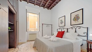 A bedroom with a bed, a window, a radiator, and artwork on the wall. - 4bnb - Lungaretta Jacuzzi Apartment (Rome)