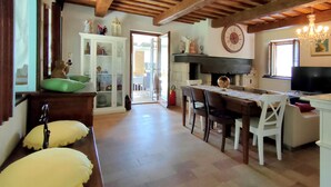 A spacious kitchen with a dining area, wooden beams, a large clock, and a view to the outside. - 3849 Villa Daya by Barbarhouse (Fano)