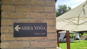 A brick wall with a sign indicating the direction to the 'AREA YOGA' section of Villa Daya. - 3849 Villa Daya by Barbarhouse (Fano)