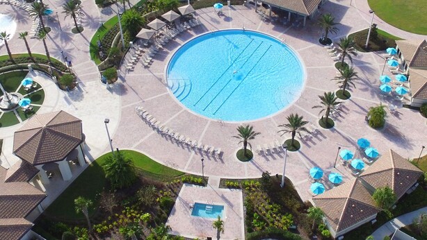 Un complexe hôtelier doté de plusieurs piscines, de chaises longues et de palmiers.