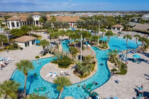 Een resort met meerdere zwembaden, palmbomen en ontspanningsruimtes.