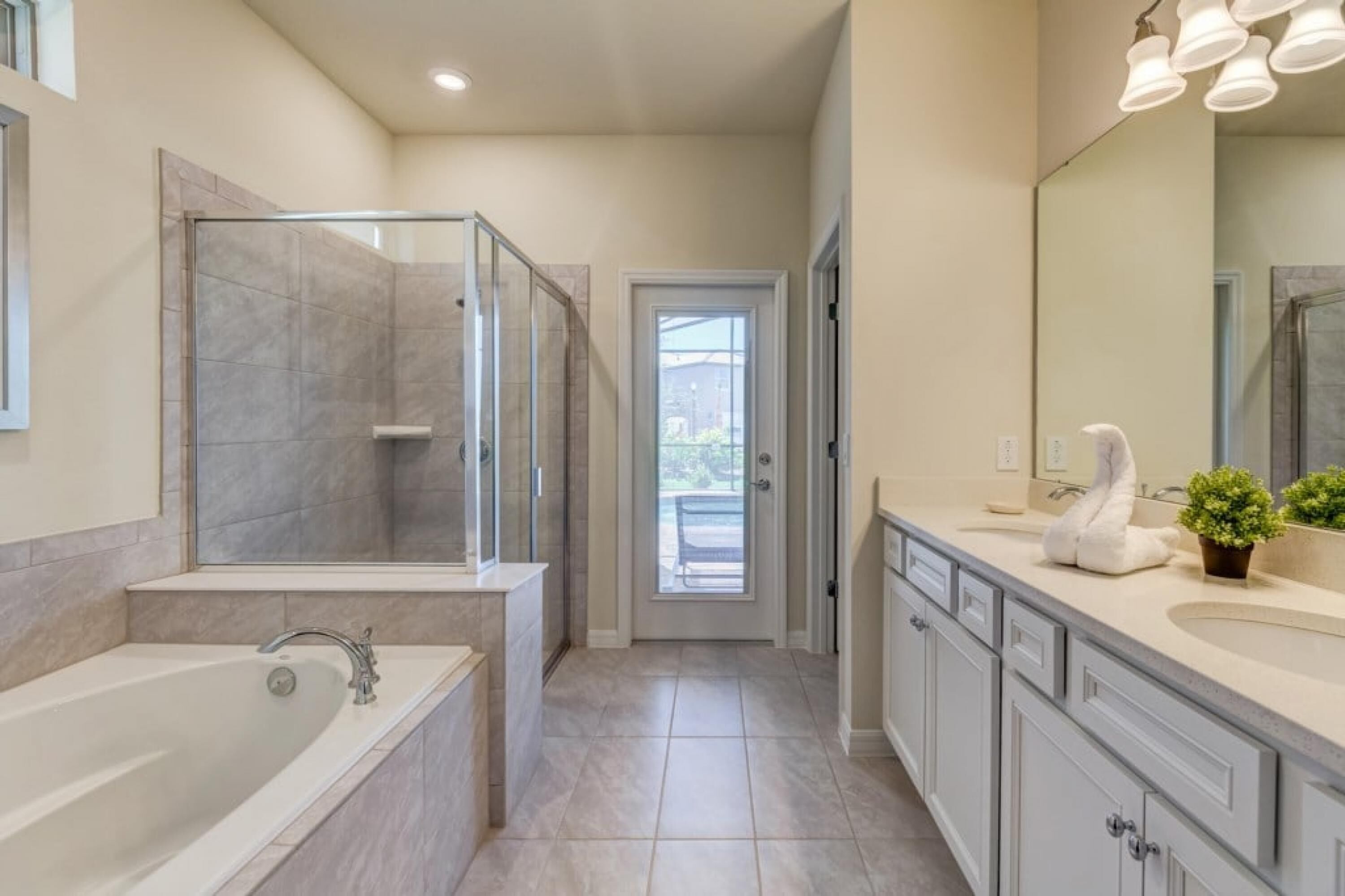 A modern bathroom with a walk-in shower, a large bathtub, and a vanity with a mirror and sink.