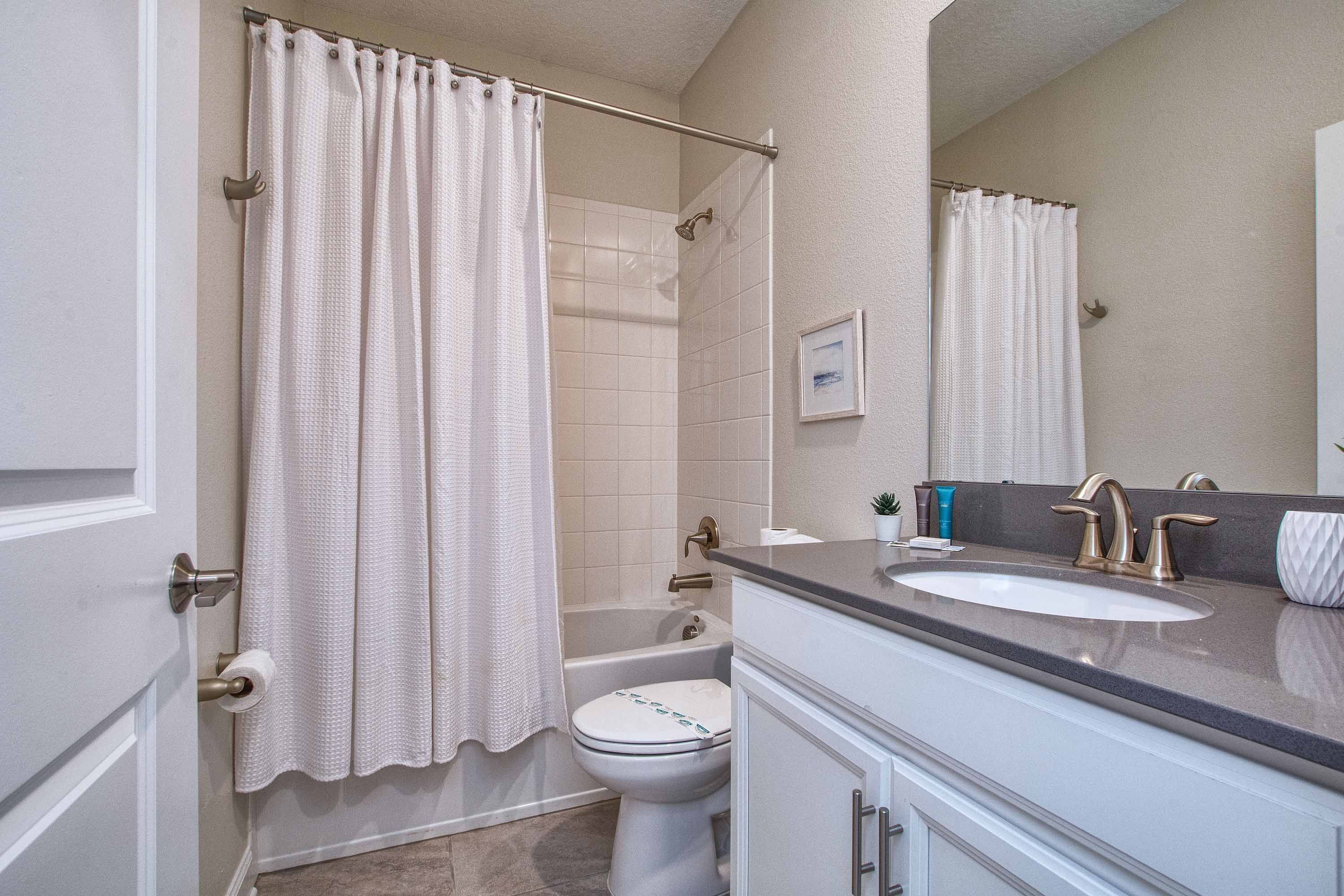 A bathroom with a bathtub, toilet, and sink.