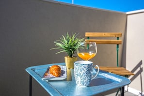 A table with a croissant, a glass of orange juice, and a blue and white patterned mug. - Villa Dika Nin (Nin)