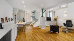 Un espacio habitable moderno con cocina, comedor y una escalera que lleva a un nivel superior.