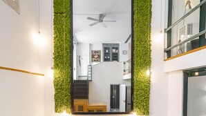 Un comedor con pared verde, un espejo grande y una mesa dispuesta para cuatro.