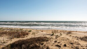 A beach with a wooden fence and sand dunes. - Pup-Friendly! Direct Oceanfront! Shorely Goodness: PierView 105 Oceanfront Condo (Nags Head)