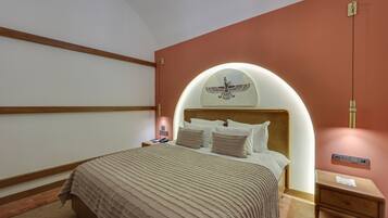 A bedroom with a bed, a nightstand, a wall-mounted light, and a decorative wall piece.
