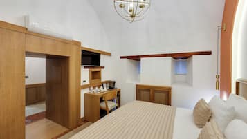 Une chambre à coucher comprenant un lit, un bureau, une armoire, un lustre et une fenêtre.