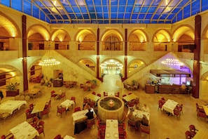 A spacious atrium with multiple dining areas, a central fountain, and a bar area. - Silk Road Museum Hotel (Tokat)