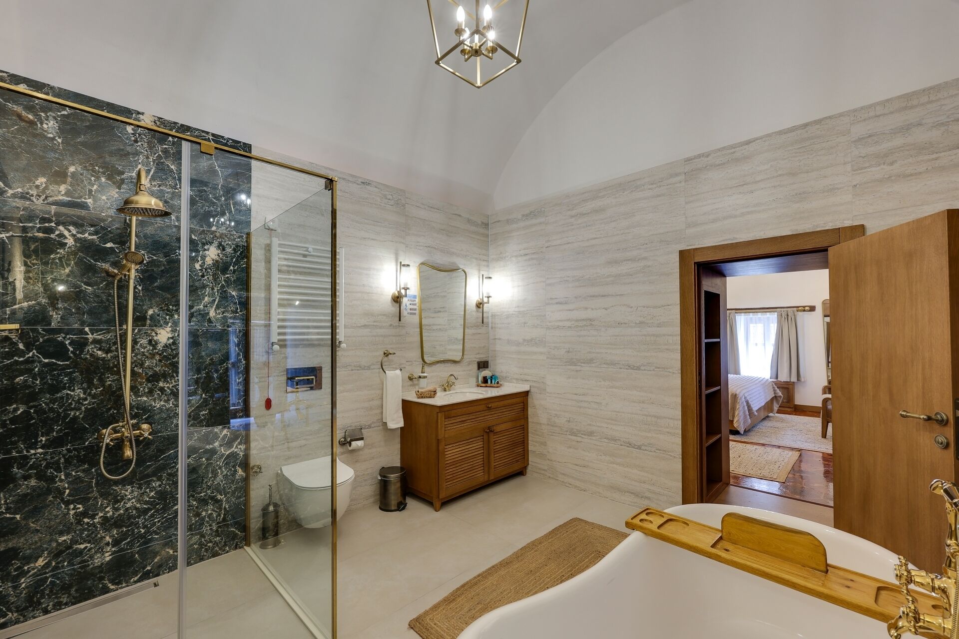 A modern bathroom with a glass-enclosed shower, a wooden vanity, and a large bathtub.