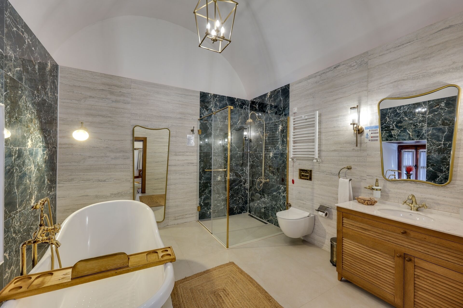 Un baño moderno con una bañera independiente, ducha con cerramiento de vidrio y un tocador con espejo.