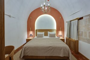 A hotel room with a large bed, a chandelier, and a curved wall arch. - Silk Road Museum Hotel (Tokat)