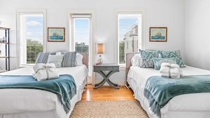 A double room with two beds, a small table, and a view of the sea through large windows. - 30A Gem | Rooftop Patio | Heated Pool (Santa Rosa Beach)