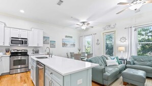 A modern kitchen with white cabinets, stainless steel appliances, and a central island. - 30A Gem | Rooftop Patio | Heated Pool (Santa Rosa Beach)