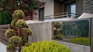 A sign for 'CHRYSALIS Studios' with a view of greenery and a building in the background. - studios Chrysalis (Volvi)