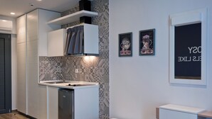 A modern kitchen with a built-in dishwasher, a white countertop, and patterned backsplash. - studios Chrysalis (Volvi)