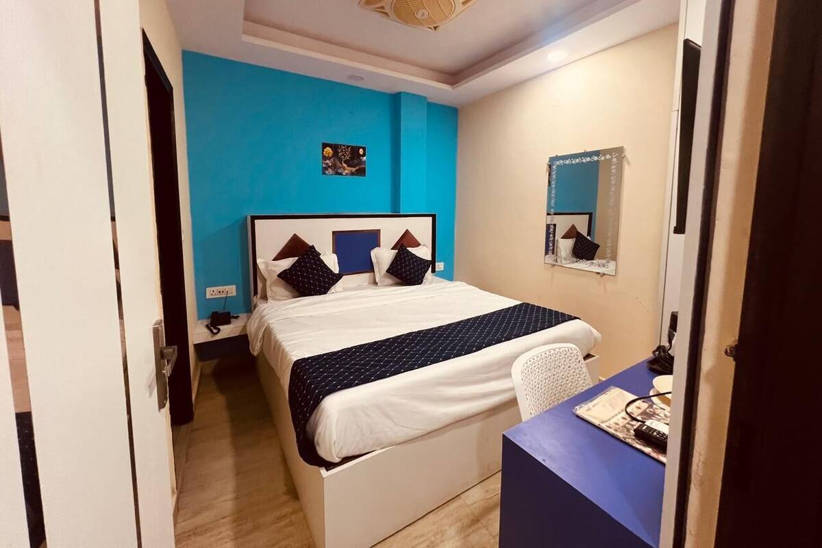 A bedroom with a bed, bedside table, and a desk.
