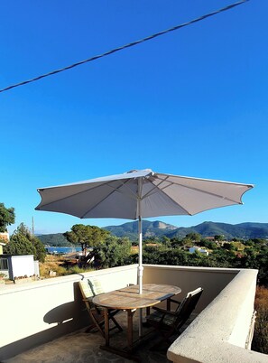 Relax on the terrace with a scenic view of the coastal area and distant mountains.