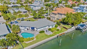 An aerial view of a residential area with a swimming pool, a dock, and a marina. - Tropical Canal Home–Pool, Sun & Water Access: Paradise Cottage in LBK by RVA (Longboat Key)