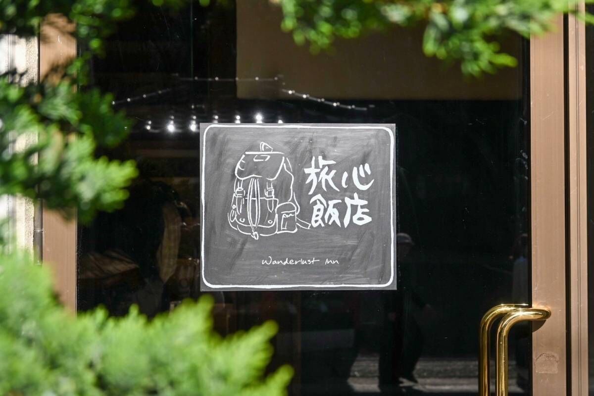 Un letrero con un dibujo de una persona y caracteres chinos, que indica un restaurante o cafetería.