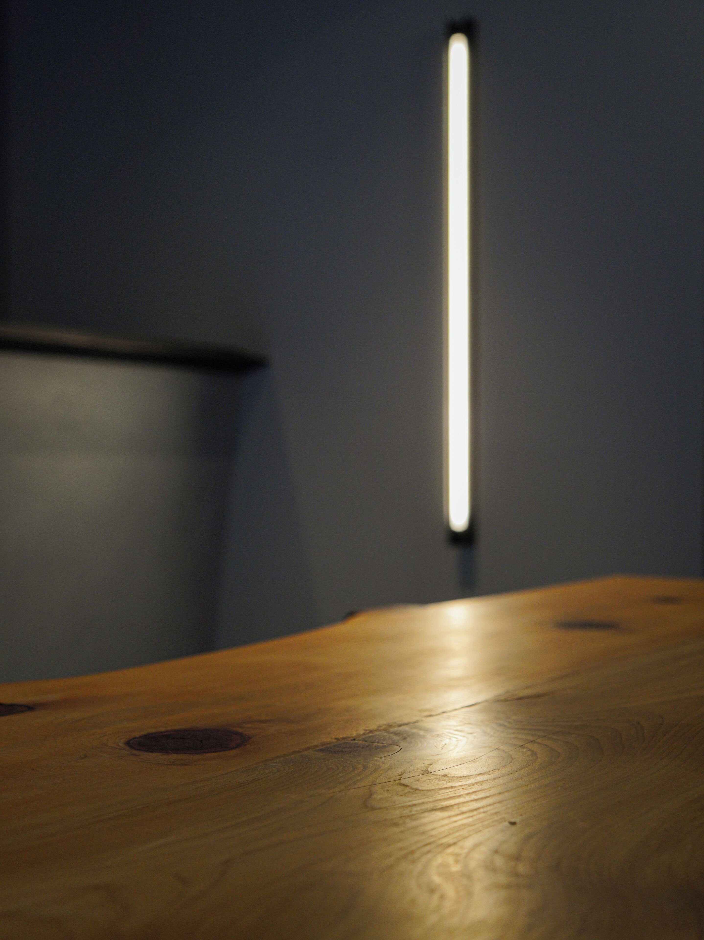 A wooden table with a light source in the background.