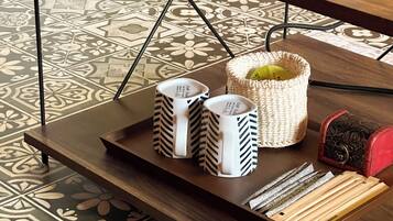 A tray with two mugs, a woven basket, and a set of wooden blocks on a table.