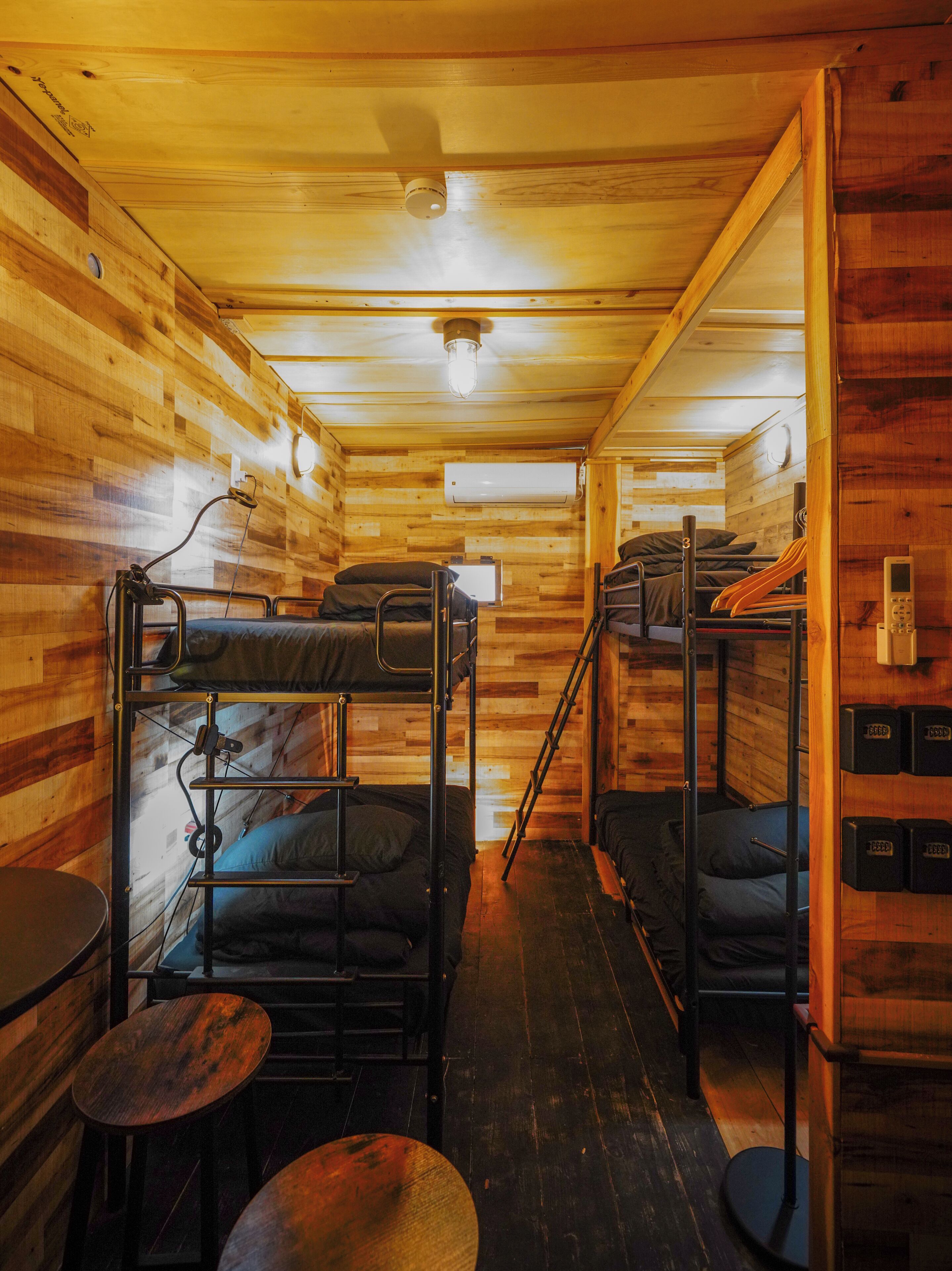 Une cabine avec des lits superposés, une petite table et une échelle.