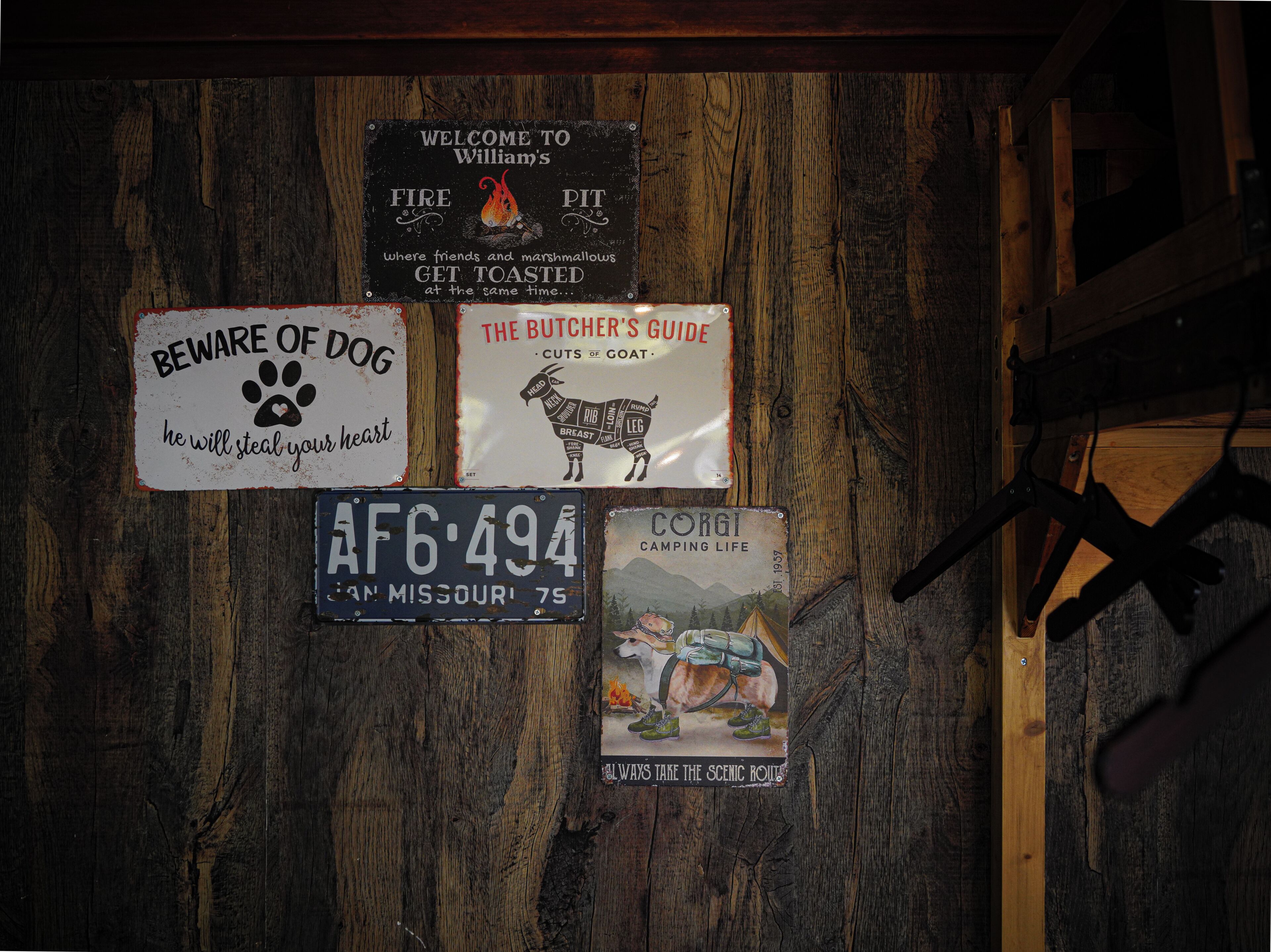 A wooden wall with various signs and a license plate.